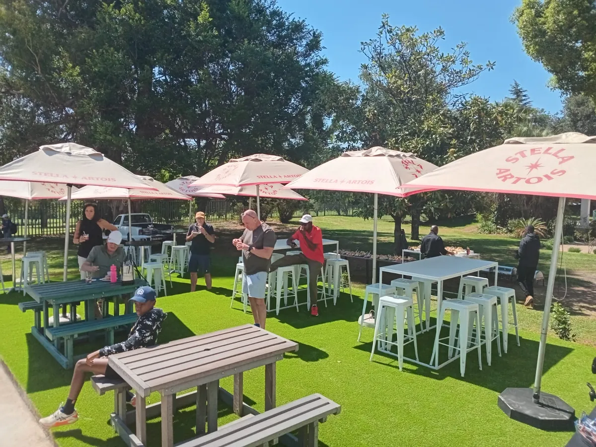 Members relaxing under umbrellas on the clubhouse lawn at the NextPoint launch
