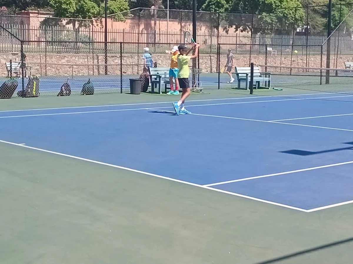A junior tossing up a serve on a NextPoint hard court